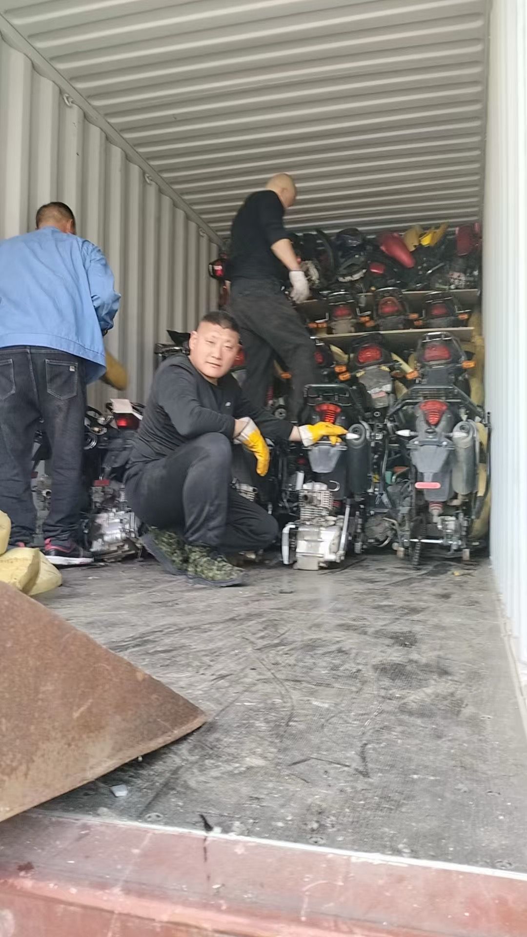 Loading crew arranging motorcycles inside a container