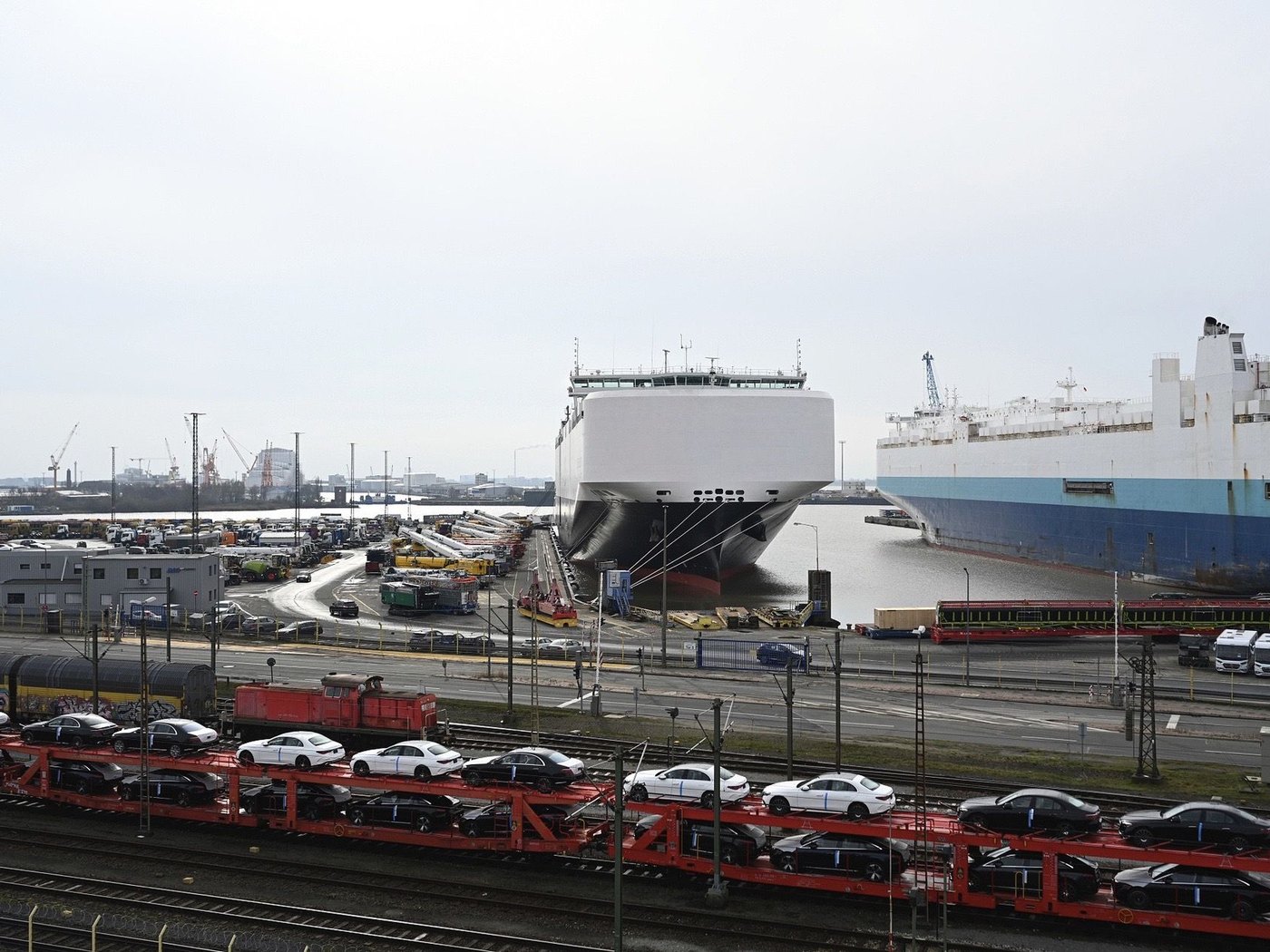 Two vehicle carriers at berth with a train of car-carrier wagons alongside