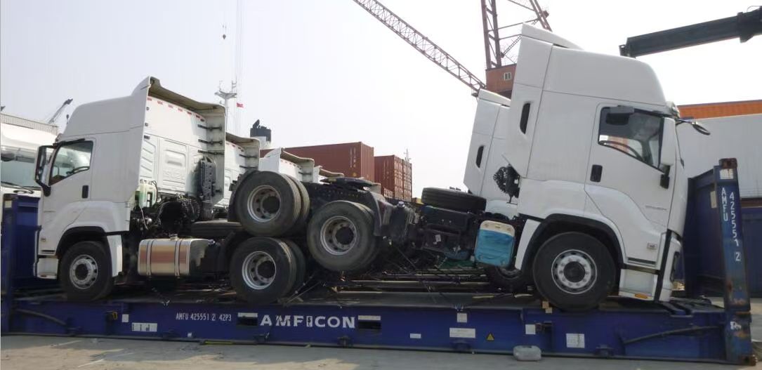 Two tractor heads stacked on a flat rack, side view