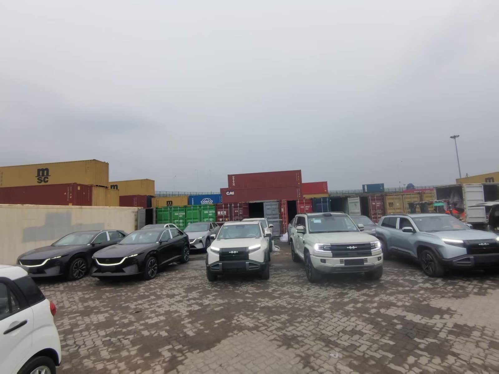 Buses and trucks positioned at a Chinese terminal before export loading